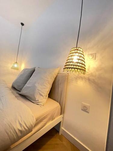 um quarto com uma cama com duas luzes em T2 neuf avec Parking et terrasse em Toulon
