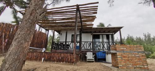 a small house with a fence and a tree at Aldea Suncunu playa y alberca privada en Tuxpan in Tuxpan de Rodríguez Cano