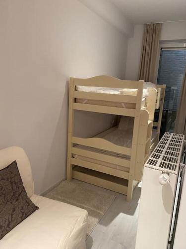 a small room with a bunk bed and a couch at Strandappartement Festival met 2 slpk in Knokke