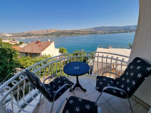 a balcony with chairs and a table and a view of the water at Apartment Matej in Trogir