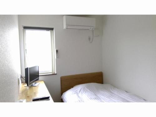 a bedroom with a bed and a desk with a television at Minshuku Cress - Vacation STAY 48561v in Biei