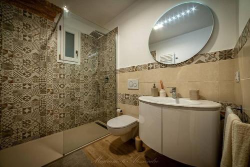 a bathroom with a sink and a toilet and a mirror at La Corte GIO' in Taurisano
