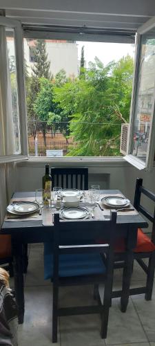 una mesa con platos y una botella de vino y una ventana en Casco Histórico en Buenos Aires