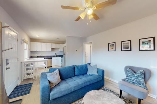 a living room with a blue couch and a ceiling fan at Sonesta 203 in Ocean City