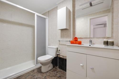 La salle de bains est pourvue de toilettes, d'un lavabo et d'un miroir. dans l'établissement Apartament Sofia, à Torrevieja