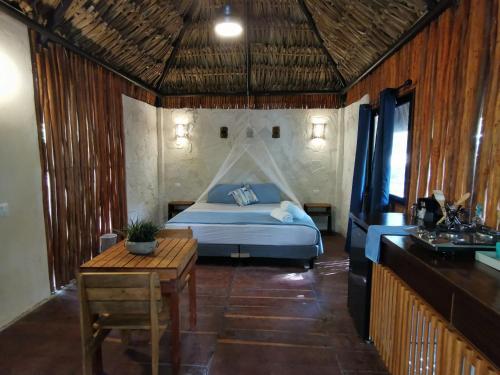 ein Schlafzimmer mit einem Bett und einem Tisch in einem Zimmer in der Unterkunft AMACA Bacalar in Bacalar