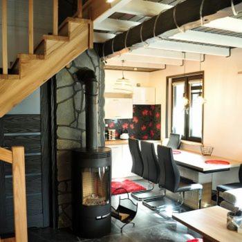 a living room with a fireplace and a table and chairs at Domki u Biesiady in Lesko