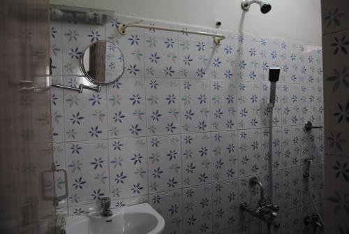a bathroom with a sink and a mirror at Just Guest House, Chennai Airport in Chennai