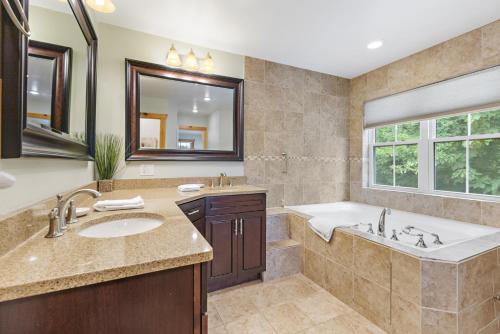 y baño con bañera, lavabo, bañera y espejo. en Stone Mountain Lodge, en Trade