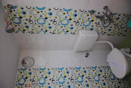 a bathroom with a toilet and a shower curtain at Just Guest House, Chennai Airport in Chennai