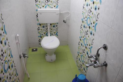 a small bathroom with a toilet and a shower at Just Guest House, Chennai Airport in Chennai