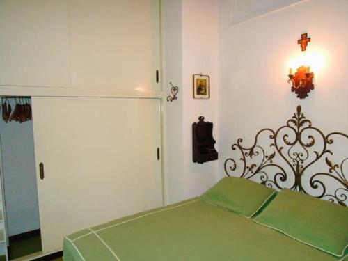 1 dormitorio con 1 cama verde en una habitación en Villa Pinetina, en Gargnano