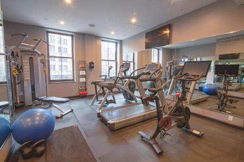 a gym with several treadmills and exercise bikes at The Frederick Hotel Tribeca in New York