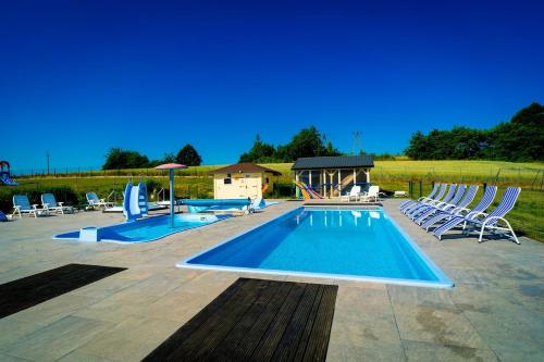 a swimming pool with chairs and a group at Perłowe Wzgórze in Ustronie Morskie