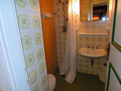 a bathroom with a toilet and a sink at Villa Pinetina in Gargnano