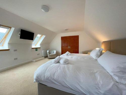 a bedroom with a large white bed with towels on it at Balloan Steading West in Dornoch