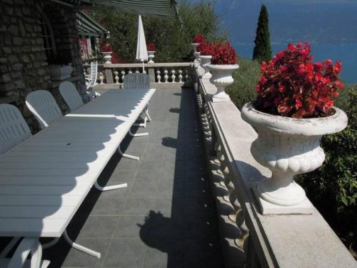 a row of white tables and white chairs and flowers at Villa Pinetina in Gargnano