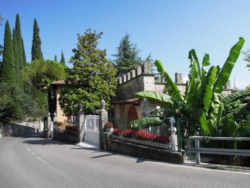 a fence in front of a house with flowers at Villa Pinetina in Gargnano