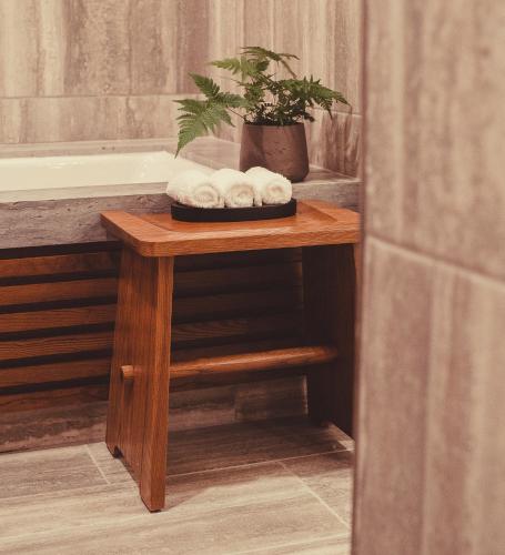 a table with three rolled towels on it next to a bath tub at Nobu Hotel Atlanta in Atlanta