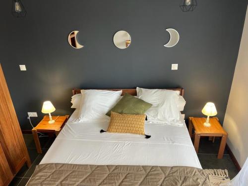 1 dormitorio con 1 cama con 2 lámparas en la pared en LA RESIDENCE DU ROCHER en Bourda