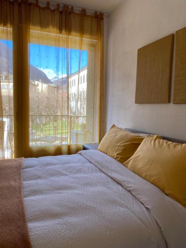 a bedroom with a bed and a large window at Valtellina Vacanze in Sondrio