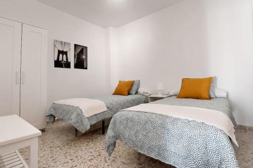 Habitación blanca con 2 camas y mesa en Casa La Balaustrada en Valverde