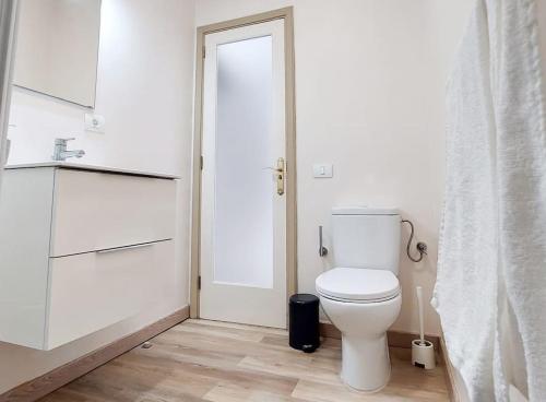 a bathroom with a white toilet and a door at Casa La Balaustrada in Valverde
