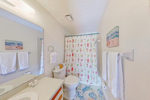 a bathroom with a toilet and a shower curtain at The Englewood Twin Palms in Englewood