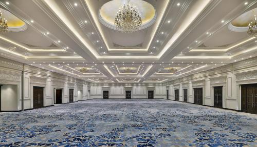an empty ballroom with a large hall with a chandelier at Voco - Riyadh by IHG in Riyadh