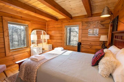 a bedroom with a bed in a wooden cabin at Stoney Brook Cabin in Boone