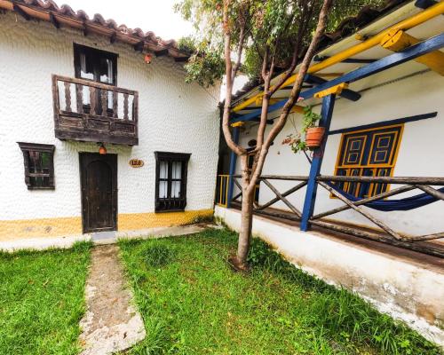 a white house with a tree in the yard at Hotel Museo la Posada del Molino in El Cocuy