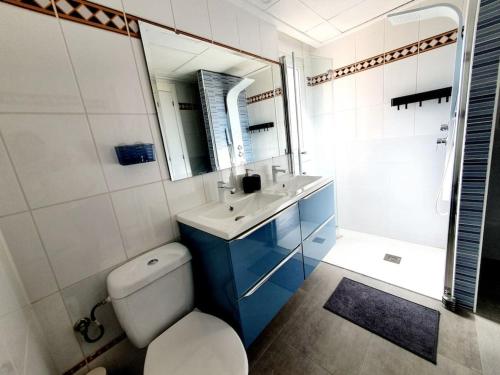 ein Badezimmer mit Toilette, Waschbecken und Spiegel in der Unterkunft Dúplex Amelia Altaona Golf in Murcia
