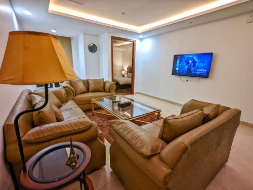 a living room with two couches and a tv at Sun-Rise view Luxury apartment Gold Crest Mall in Lahore