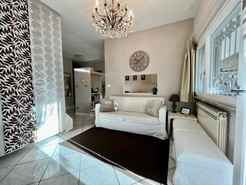 sala de estar con sofá blanco y lámpara de araña en Your Studio Apartment in Sirmione, en Sirmione