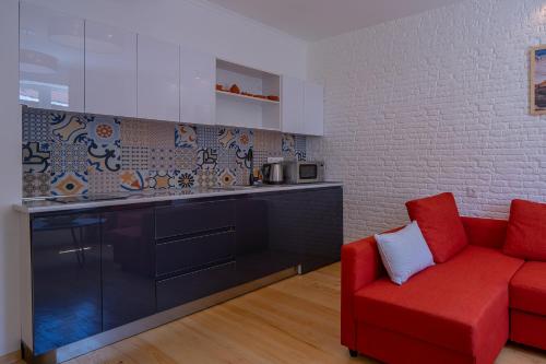 a living room with a red couch and a kitchen at svaneti apartment's in Mestia