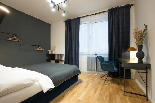 1 dormitorio con cama, escritorio y ventana en Bright stylish apartment with a balcony in a top location en Viena