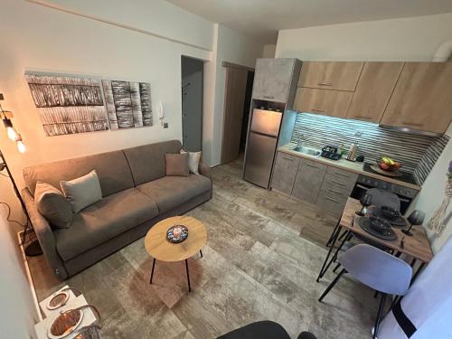 a living room with a couch and a table and a kitchen at Centro Alexandroupolis in Alexandroupoli