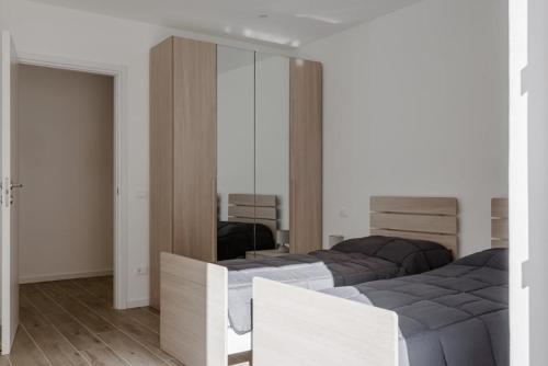 a bedroom with two beds and a mirror at Chalet Francesca in Pieve di Cadore