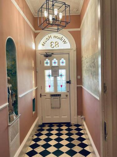 a hallway with a white door and a checkered floor at Stunning seafront apartment in Brighton & Hove