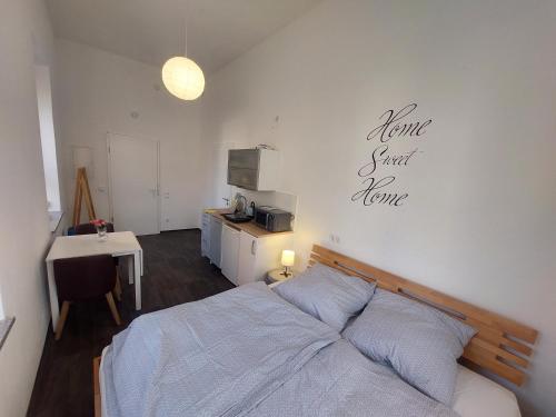 a bedroom with a bed and a table and a kitchen at Apartments im Mardefeldpalais in Ansbach