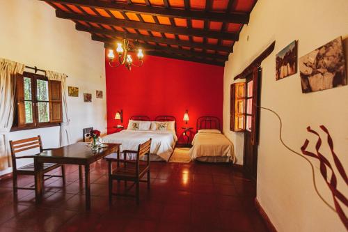 1 dormitorio con 2 camas, mesa y sillas en Finca Las Margaritas en Chicoana