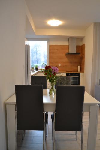 una cucina con tavolo, sedie e vaso di fiori di Elegant Escape apartment II - City Centre a Bratislava