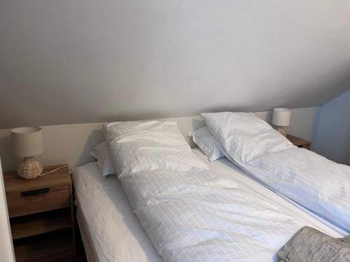 a bedroom with two beds with white sheets and pillows at Akureyri apartments in Akureyri