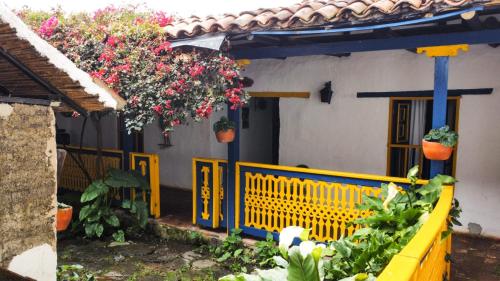 a yellow fence in front of a house with flowers at Hotel Museo la Posada del Molino in El Cocuy