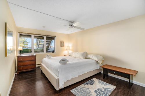 a bedroom with a bed and a table and a window at South Beach 26 in Glen Arbor