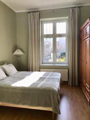 a bedroom with a large bed and a window at Apartamenty Vincent Sopot in Sopot