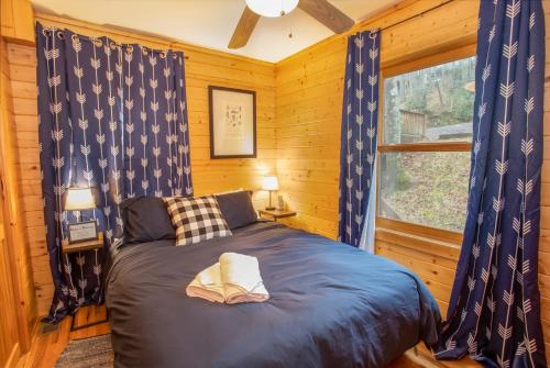 ein Schlafzimmer mit einem Bett in einem Blockhaus in der Unterkunft New River Lure in West Jefferson