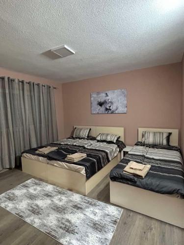 twee bedden in een slaapkamer met twee tapijten bij Apartments & Restaurant Despina in Prilep