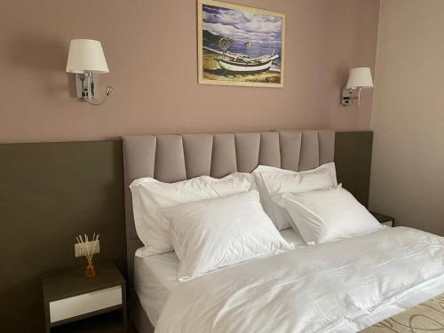 a bed with white sheets and pillows in a bedroom at Doanesia Premium Hotel & Spa in Tirana