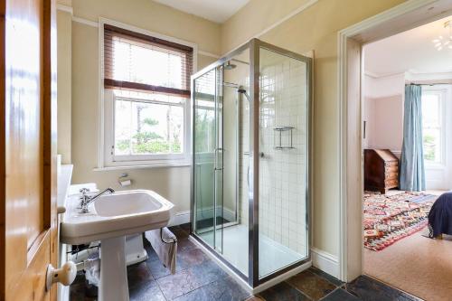 ein Bad mit einer Dusche und einem Waschbecken in der Unterkunft Downedge in Brading
